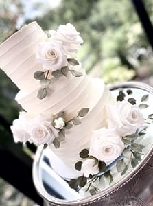 white wedding cake with a cascade of white and blue flowers