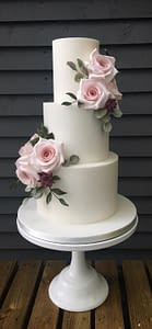 white wedding cake with burgundy and pink flowers