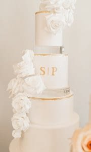 gold leaf edges and monogram white wedding cake