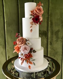 white wedding cake with autumn coloured sugar flowers and leaves