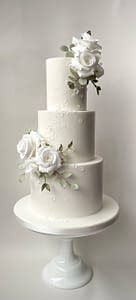 white wedding cake with scattered flowers