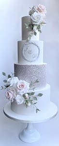 wedding cake with silver sequins and pink flowers