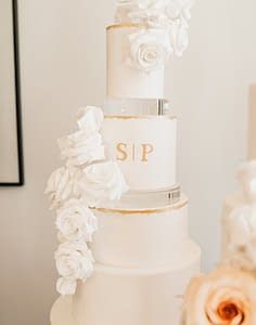 gold leaf edges and monogram white wedding cake