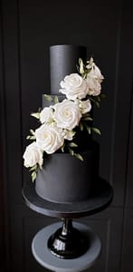 black wedding cake with white flower cascade