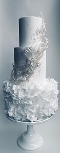 white wedding cake with wafer paper ruffles, pearls and rice paper sails