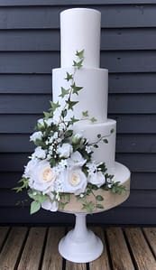 Wedding cake with flowers and ivy coming up from the base