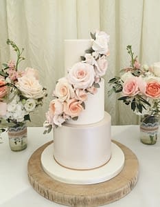 wedding cake with cascacde of peach pink and apricot coloured flowers
